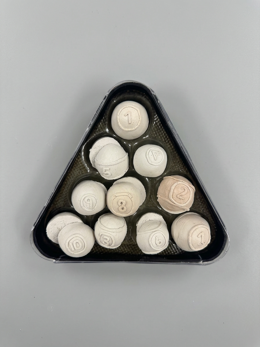 Bisque-fired clay balls held in a final triangular mold.
