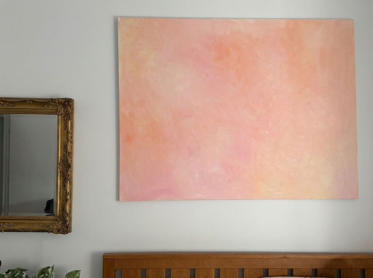 Large peach and pink acrylic canvas hung on a wall.